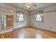 Bright bedroom with hardwood floors, ceiling fan, and windows with decorative curtains at 4464 Chatham Dr, Brownsburg, IN 46112