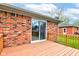 A cozy wooden deck adjoins a brick home featuring a sliding glass door and backyard access, perfect for relaxation at 4464 Chatham Dr, Brownsburg, IN 46112