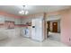 Traditional eat-in kitchen featuring white cabinets and appliances, and a classic chandelier at 4464 Chatham Dr, Brownsburg, IN 46112
