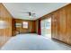 A spacious room with wood paneling, ceiling fan, and sliding doors to the deck at 4464 Chatham Dr, Brownsburg, IN 46112