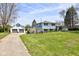A bright two-story home with a detached garage and an upper deck, showcasing the well-maintained landscaping at 5014 Dawn St, Anderson, IN 46013