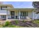 Inviting covered front porch with brick decor, seating, and well-manicured front yard at 5014 Dawn St, Anderson, IN 46013