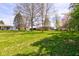 Large front yard with mature trees and a well-maintained lawn at 5014 Dawn St, Anderson, IN 46013