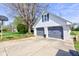Two car attached garage with grey doors and a basketball hoop on the extended driveway at 5014 Dawn St, Anderson, IN 46013