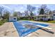 Pool with diving board has a blue cover with standing water on top, surrounded by mature trees at 5014 Dawn St, Anderson, IN 46013