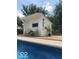 View of the pool house from beside the pool featuring chairs and a small table on the pool deck at 5014 Dawn St, Anderson, IN 46013