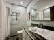 Well-lit bathroom featuring modern sink, vanity, and large mirror, accented by tiled shower and grab bars at 5205 Mosswood Ct, Indianapolis, IN 46254