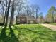 Two-story brick home with a well-manicured lawn, mature trees, and a red front door at 5205 Mosswood Ct, Indianapolis, IN 46254