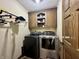 Functional laundry room equipped with modern washer, dryer, and extra storage cabinets for convenience at 5205 Mosswood Ct, Indianapolis, IN 46254