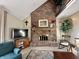 Cozy living room with a brick fireplace, large TV, and comfortable seating area at 5205 Mosswood Ct, Indianapolis, IN 46254