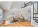 Modern living room with hardwood floors, a stone accent wall, and spiral staircase at 5209 Melrose Ave, Indianapolis, IN 46241
