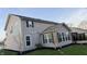 Back exterior view of home, showcasing its vinyl siding, well-kept lawn, and serene backyard at 5529 W Turnbuckle Pl, McCordsville, IN 46055