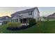 Backyard view of the home featuring a landscaped lawn and covered patio at 5529 W Turnbuckle Pl, McCordsville, IN 46055