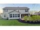 Captivating backyard featuring a covered patio with overhead lighting and professionally installed landscaping at 5529 W Turnbuckle Pl, McCordsville, IN 46055