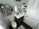 Well decorated bathroom with black fixtures, including a round mirror, wall decor, and modern sink at 5529 W Turnbuckle Pl, McCordsville, IN 46055