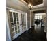 Elegant foyer with dark hardwood floors, paneled white doors, and a modern chandelier, creating a grand entrance at 5529 W Turnbuckle Pl, McCordsville, IN 46055