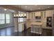 Modern kitchen with stainless steel appliances, light countertops, and custom light fixture at 5529 W Turnbuckle Pl, McCordsville, IN 46055