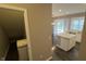 Open-concept living space with island seating, and access to storage space and backyard at 5529 W Turnbuckle Pl, McCordsville, IN 46055