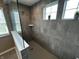Tiled walk-in shower features dual windows and a built-in shelf at 5529 W Turnbuckle Pl, McCordsville, IN 46055