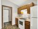 Traditional kitchen with white appliances, wood cabinets, and durable plank flooring at 5666 Ensley Ct, Indianapolis, IN 46254