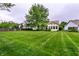 Large backyard featuring a well-kept lawn with mature trees at 5845 Arrowleaf Ln, Carmel, IN 46033