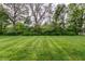 Expansive backyard with lush green lawn and mature trees at 5845 Arrowleaf Ln, Carmel, IN 46033