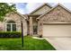 Close-up of a brick-front home highlighting the covered entry, manicured lawn, and attached two-car garage at 5845 Arrowleaf Ln, Carmel, IN 46033