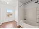 Bright bathroom showcasing a tub and shower combination, a window, and wood-look flooring at 5924 Skyward Ln, Indianapolis, IN 46234
