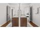 Well-lit bathroom featuring double sinks, wood-look floors, and bright lighting, offering a functional design at 5924 Skyward Ln, Indianapolis, IN 46234