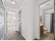 Hallway featuring neutral colored walls, neutral carpet, a door, and access to a bathroom at 5924 Skyward Ln, Indianapolis, IN 46234