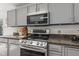 Kitchen closeup featuring stainless steel appliances and gray cabinets at 5924 Skyward Ln, Indianapolis, IN 46234