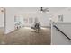 Bright living room features a modern ceiling fan, large windows offering serene views, and plush carpeting throughout at 5924 Skyward Ln, Indianapolis, IN 46234