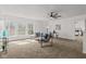 Bright living room features a modern ceiling fan, large windows offering serene views, and plush carpeting throughout at 5924 Skyward Ln, Indianapolis, IN 46234