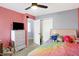 Bedroom with rainbow bedding, ceiling fan, and gray/red accent walls at 5937 Terrytown Pkwy, Indianapolis, IN 46254