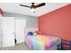 Bedroom with rainbow bedding, ceiling fan, and gray/red accent walls at 5937 Terrytown Pkwy, Indianapolis, IN 46254