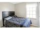 Bright bedroom featuring a window, light walls, and a large dark-wood headboard at 5937 Terrytown Pkwy, Indianapolis, IN 46254