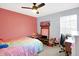 Bedroom with rainbow bedding, ceiling fan, and gray/red accent walls at 5937 Terrytown Pkwy, Indianapolis, IN 46254