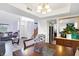Open-concept dining room leading to living area with stairs, modern chair, and butler's pantry at 5937 Terrytown Pkwy, Indianapolis, IN 46254