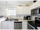 Efficient kitchen with white cabinetry, stainless steel appliances, and lots of natural light at 5937 Terrytown Pkwy, Indianapolis, IN 46254