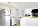 Kitchen with stainless steel fridge and bar area overlooking living room with fireplace and TV at 5937 Terrytown Pkwy, Indianapolis, IN 46254