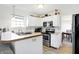 Open kitchen with stainless steel appliances and a breakfast bar; dining room in background at 5937 Terrytown Pkwy, Indianapolis, IN 46254