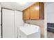 This laundry room features a modern white washer and dryer set with wood cabinets at 5937 Terrytown Pkwy, Indianapolis, IN 46254