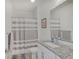 Bright bathroom featuring granite counters, white cabinets, shower with curtain and a large mirror at 620 Pomeroy St, Indianapolis, IN 46202