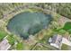 Stunning aerial view of a home nestled beside a serene, tree-lined pond, offering a peaceful and picturesque setting at 6507 Tram Ct, Indianapolis, IN 46260