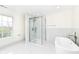 Modern bathroom features a glass-enclosed shower, soaking tub, and stylish marble tile, offering a luxurious experience at 6507 Tram Ct, Indianapolis, IN 46260