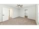Spacious bedroom with plush carpeting, neutral walls, a ceiling fan, and access to a walk-in closet and ensuite bathroom at 6507 Tram Ct, Indianapolis, IN 46260
