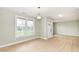 Bright living room featuring light wood flooring, decorative wall panels, and a large window offering natural light at 6507 Tram Ct, Indianapolis, IN 46260