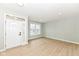 Bright living room with wood floors, decorative wall panels, a large window, and a modern front door at 6507 Tram Ct, Indianapolis, IN 46260