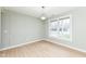 Bright living room featuring light wood flooring, decorative wall panels, and a large window offering natural light at 6507 Tram Ct, Indianapolis, IN 46260