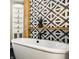 Bright bathroom featuring a soaking tub, wooden accents, and eye-catching patterned tile at 654 E 79Th St, Indianapolis, IN 46240